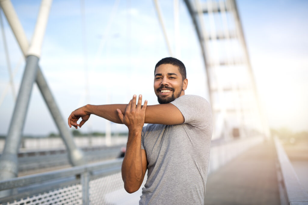 レジリエンス:私たちの隠れた力 attractive smiling sportsman warming up his body outdoor training