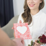 お姉さんへの誕生日カード: あなたの人生の伴侶への愛と感謝の贈り物 man giving pink greeting card woman