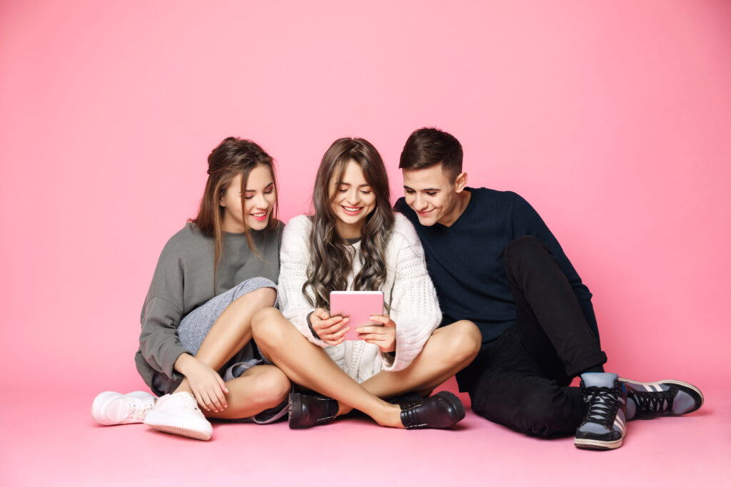 バレンタインデーの友達への手紙:誠実な言葉で友情を祝う young friends smiling looking tablet pink